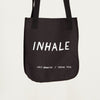 black tote bag with the word "Inhale" in white lettering