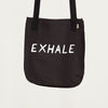 reverse side of black tote bag, with the word "Exhale" in white lettering